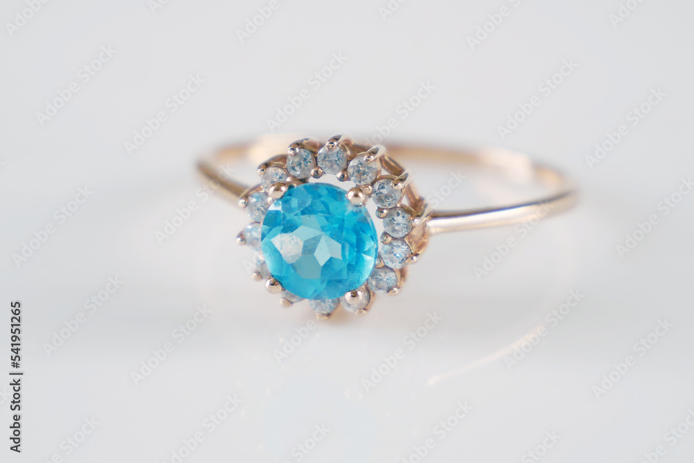 beautiful ring with blue topaz and many white diamonds on white background beautiful ring with blue topaz and many white diamonds on white background