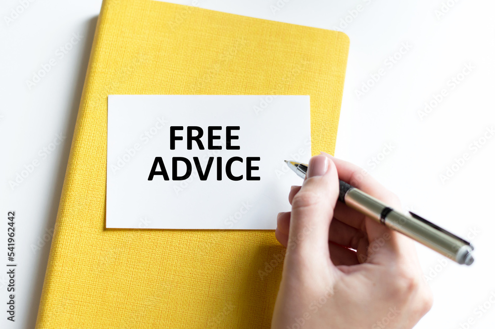 EXPERT ADVICE text on a white card on a yellow notebook next to the hand of a person with a pen writes the text EXPERT ADVICE text on a white card on a yellow notebook next to the hand of a person with a pen writes the text