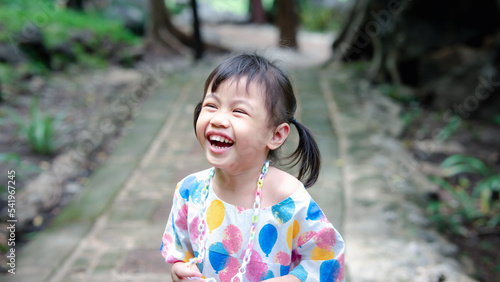 Close up portrait of four years old happy laughing beautiful Asian girl, little preschooler child with smile emotion on face.