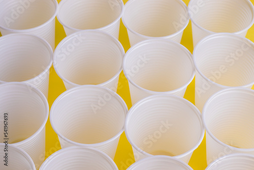 copos de plastico em fundo amarelo photo