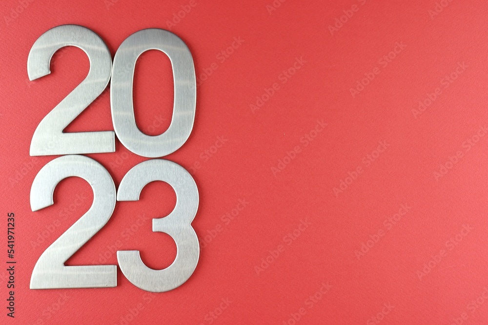 Top view silver numerals with the new year on a red monochrome background Top view silver numerals with the new year on a red monochrome background