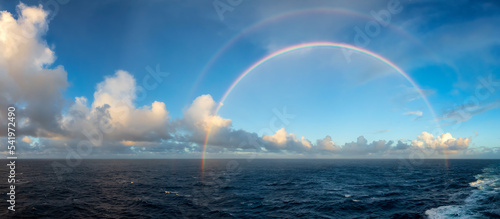 Foto Dramatic Colorful Sunrise Sky over North Atlantic Ocean with Rainbow