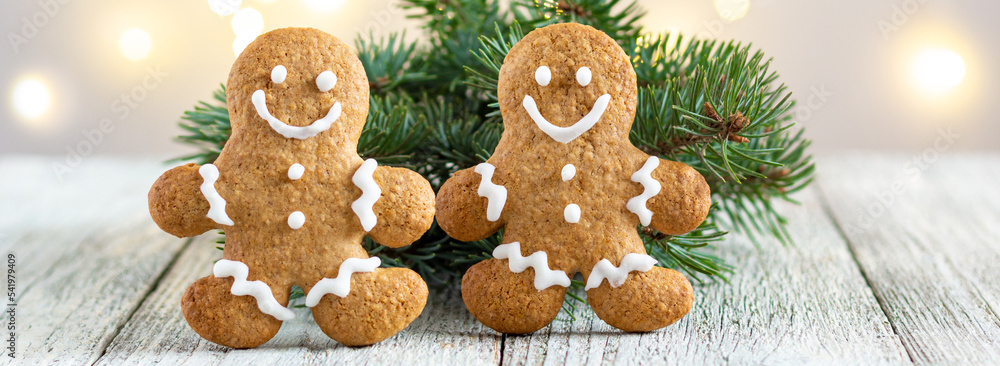 banner of Gingerbread man with fir tree branch on bokeh lights background banner of Gingerbread man with fir tree branch on bokeh lights background