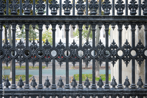 Closeup black wrought iron fence public place