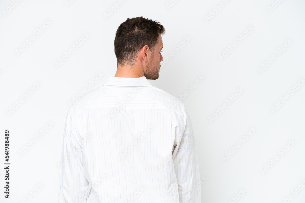 Young caucasian handsome man isolated on white background in back position and looking side Young caucasian handsome man isolated on white background in back position and looking side
