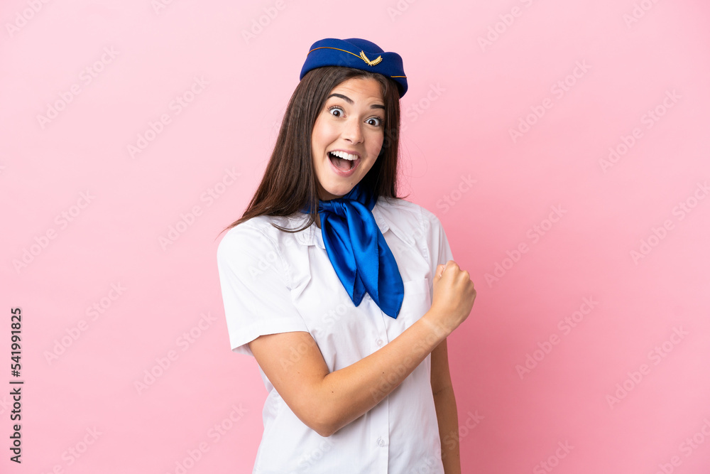 Airplane stewardess Brazilian woman isolated on pink background celebrating a victory Airplane stewardess Brazilian woman isolated on pink background celebrating a victory