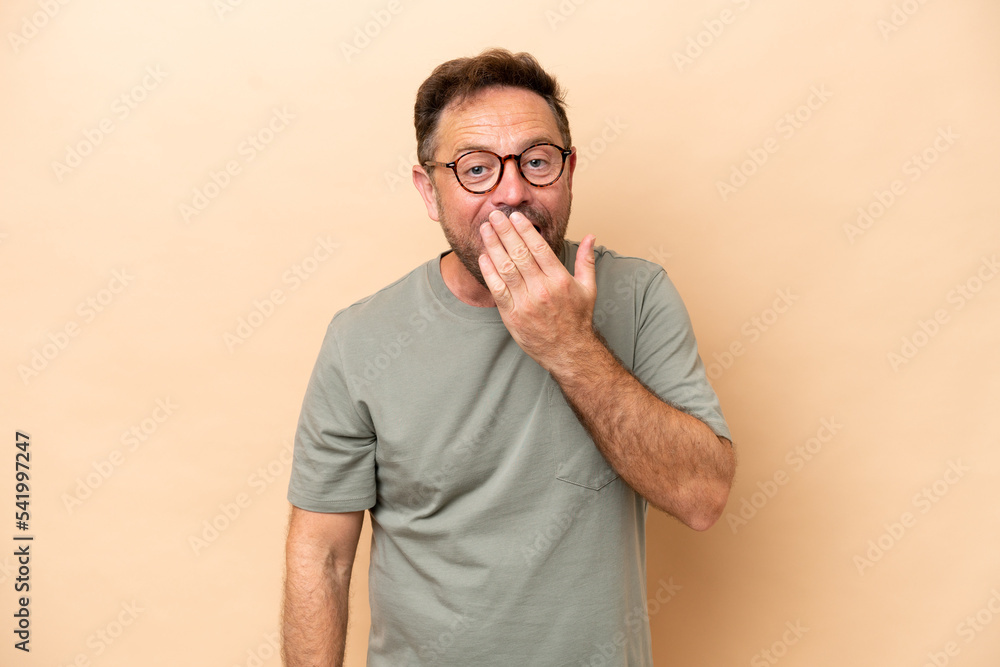 Middle age caucasian man isolated on beige background happy and smiling covering mouth with hand Middle age caucasian man isolated on beige background happy and smiling covering mouth with hand