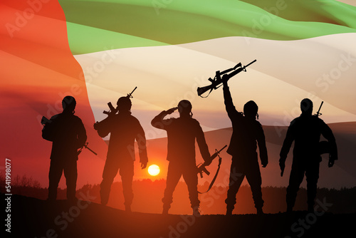 Silhouettes of soldiers on background of UAE flag and the sunset or the sunrise. Concept of national holidays. Commemoration Day.