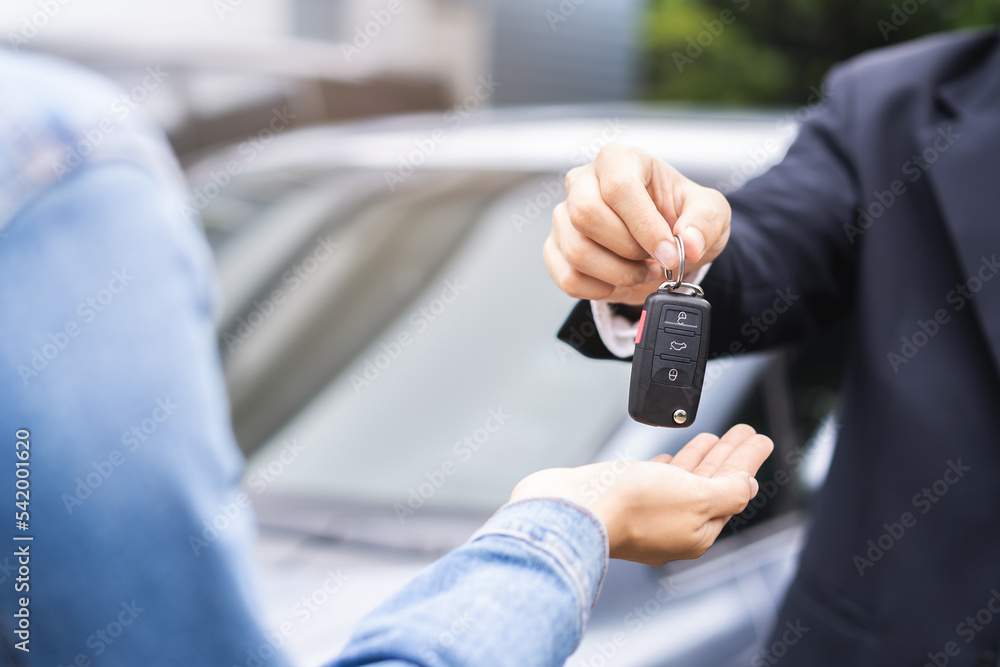 Business car rental, sell or buy service, dealership hand of agent dealer, sale man giving auto key of vehicle to customer renter, buyer young woman receiving, client or tenant, transfer automobile.