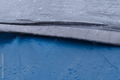 Raindrops on a blue tent close-up.