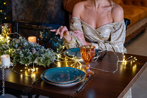 a luxurious woman at a served christmas table is waiting for a partner