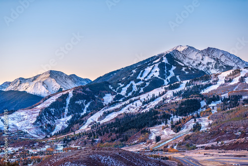 Aerial high angle view of ski resort town city of Aspen, Colorado after early winter snow on Buttermilk mountain with valley in autumn fall