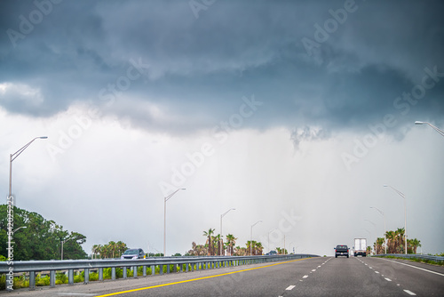 Interstate highway road 95 i95 near Daytona Beach, Florida with cars traffic by storm stormy gray blue clouds cloudy cloud cover photo