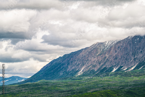 Kebler pass mountain range landscape view on snowcapped Rocky mountains with snow by aspen trees forest wilderness in summer