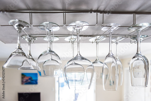 Closeup of modern kitchen interior design with upside down hanging empty wine glasses rack in room for storage