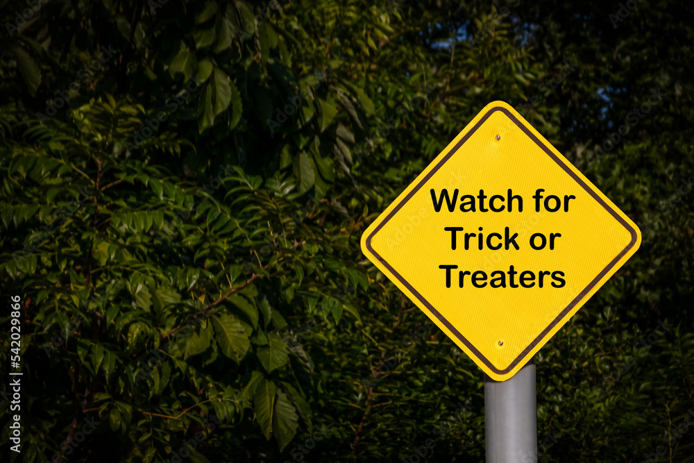 Closeup - Yellow Blank Sign against dark green foliage - Reads Watch for Trick or Treaters