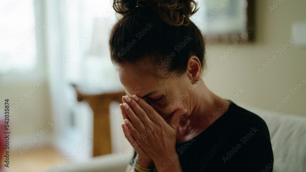 Middle age hispanic woman suffering for domestic violence with bruise on eyes crying at home Middle age hispanic woman suffering for domestic violence with bruise on eyes crying at home