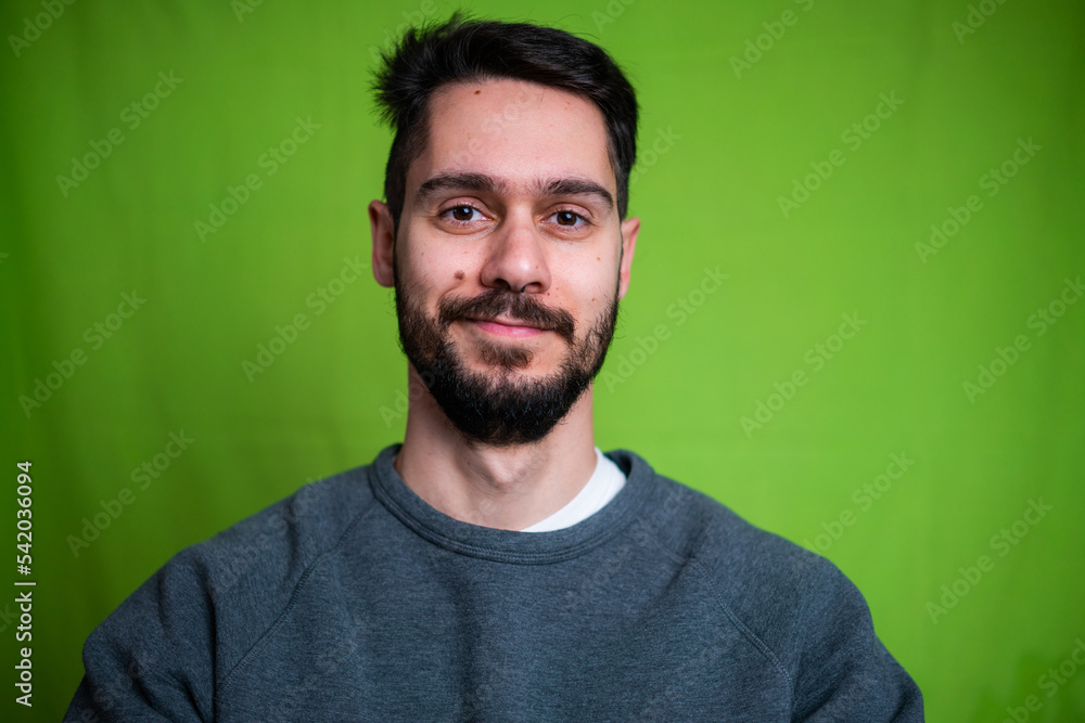 Young man with casual clothes, posing on green background Young man with casual clothes, posing on green background