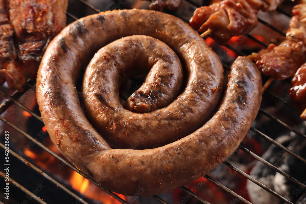 sausages on the grill. Boerewors sausage on a braai. South African braai  Photos | Adobe Stock