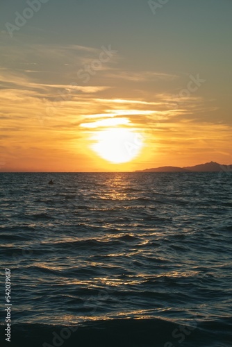 Vertical shot of a seascape during a sunset © Timm10/Wirestock Creators