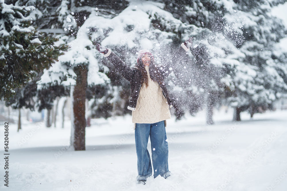 Beautiful woman standing among snowy trees and enjoying first snow. Holidays, rest, travel concept. Beautiful woman standing among snowy trees and enjoying first snow. Holidays, rest, travel concept.