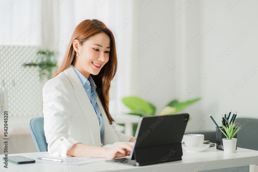 Attractive and beautiful Asian business woman Work at your desk using your digital tablet's touchpad. online work concept Attractive and beautiful Asian business woman Work at your desk using your digital tablet's touchpad. online work concept