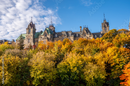 Towers of the East Block on Canada's Parliament Hill seen rising in the distance above trees on the Rideau Canal.