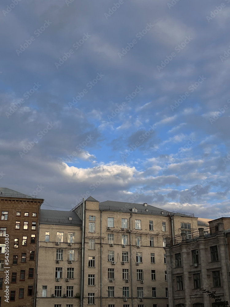 Sunset in city center in Kyiv, Ukraine, yards at Kreschatyk street. Colored cloudy sky, dusk, sunset in the city. Architectural concept. High quality vertical image