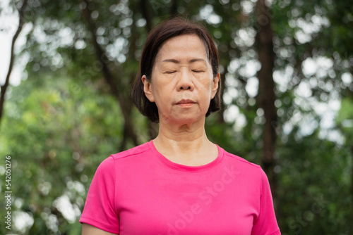 an elderly woman doing yoga at a park