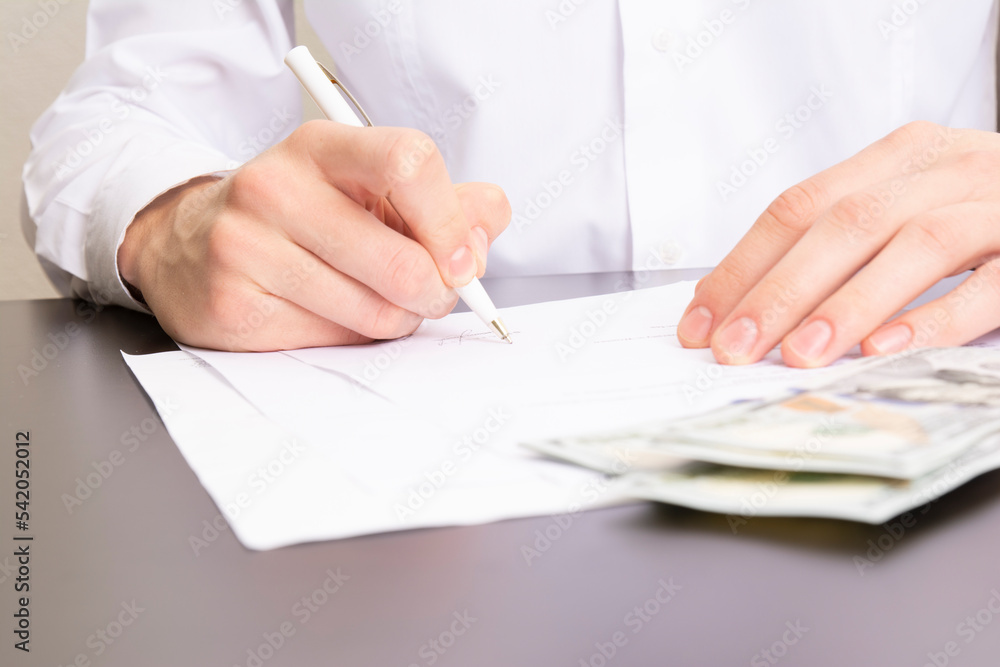 close shot of a human hand writing something on the paper on the foreground, business concept close shot of a human hand writing something on the paper on the foreground, business concept