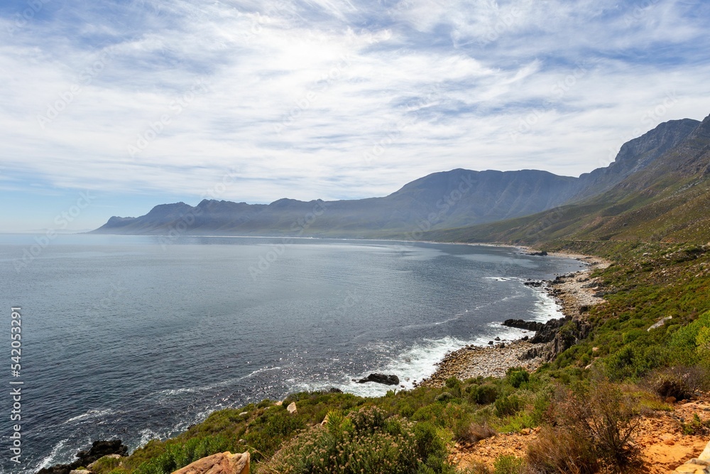 Aerial view of lush green coast of False Bay under blue cloudy sky in Africa