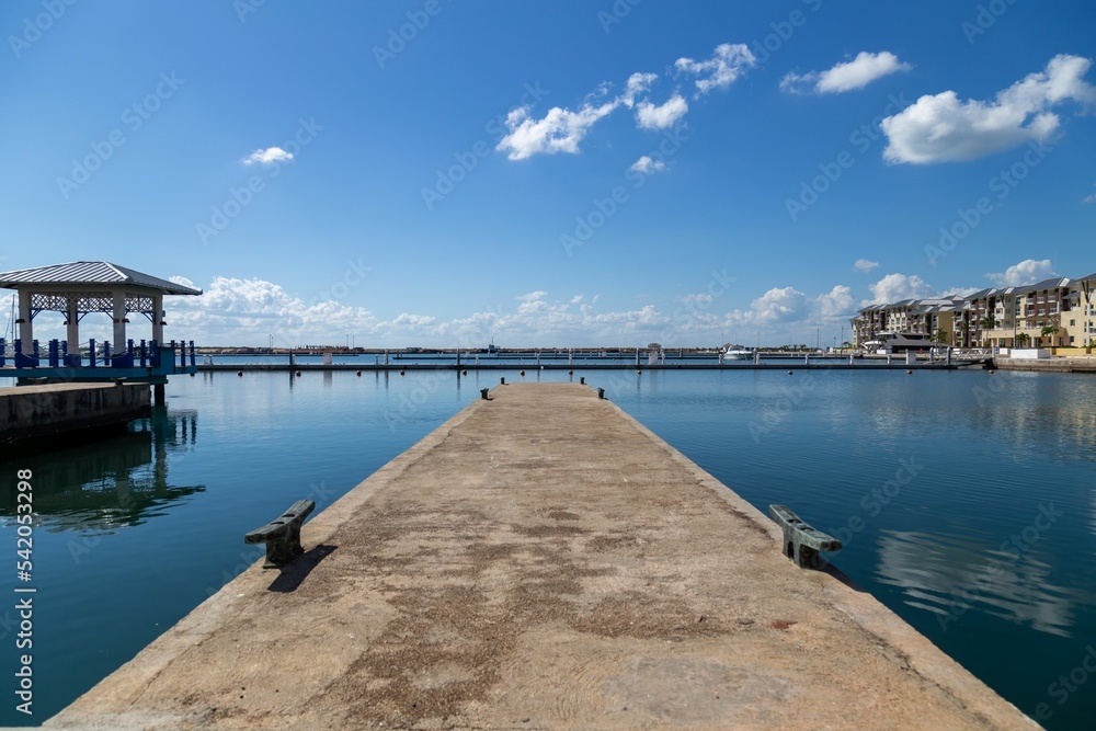 Concrete dock over the lake under blue cloudy sky background