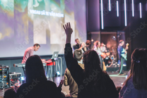 Hands in the air of a woman who praise God at church service