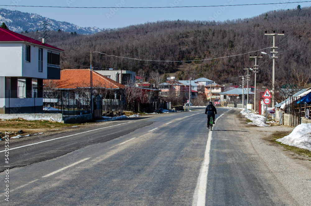 rural city with bcyclist on asphalt road