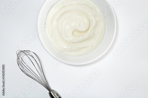 Fotografia whipped cream and whisk on white background