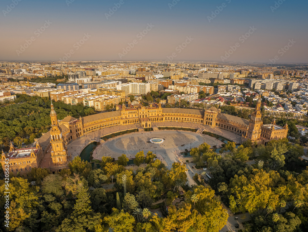 The drone aerial view of Spain Square (Plaza de Espana) in Seville (Sevilla) city, Andalusia, Spain. The Plaza is a landmark example mixing elements of the Baroque Revival, Renaissance Revival and Mo The drone aerial view of Spain Square (Plaza de Espana) in Seville (Sevilla) city, Andalusia, Spain. The Plaza is a landmark example mixing elements of the Baroque Revival, Renaissance Revival and Mo