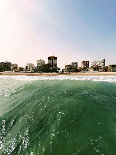 Wave against a beach with houses