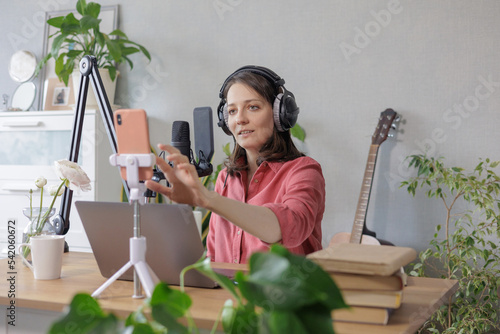 woman in a home office records podcast audio content with a microphone and headphones and a labrador dog. a young successful female journalist or radio presenter records music or broadcasts on the © MyJuly