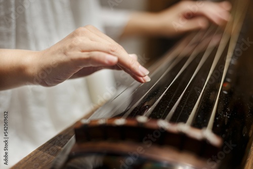 Female playing guqin, a plucked seven-string Chinese musical instrument
