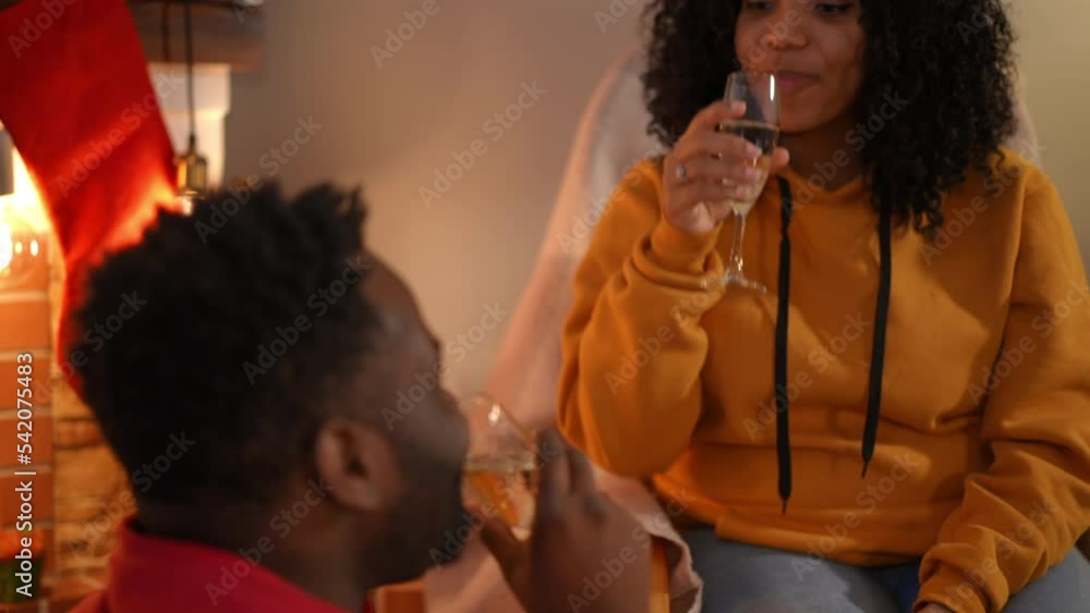 African American woman toasting champagne with man drinking beverage talking and smiling. happy relaxed young couple celebrating New Year's eve together at home African American woman toasting champagne with man drinking beverage talking and smiling. happy relaxed young couple celebrating New Year's eve together at home