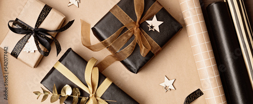 Christmas background with gift boxes and rolls of kraft wrapping paper