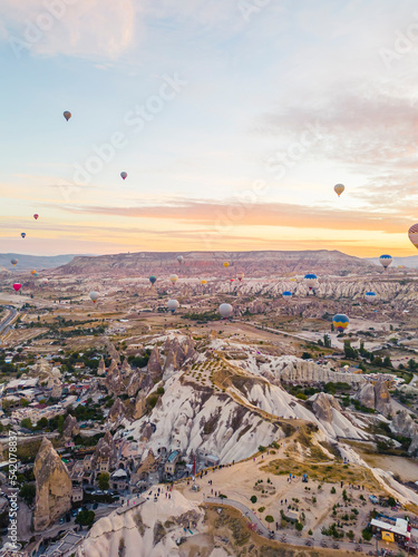 Spectacular drone view of hot air balloons flying over the underground city and fairy chimneys valley in Nevsehir, Goreme, Cappadocia Turkey. High quality photo 
