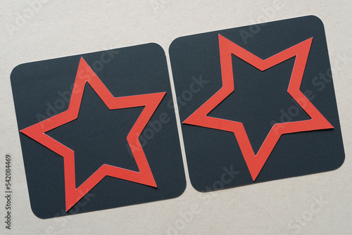 red stars on grungy black squares and blank beige paper
