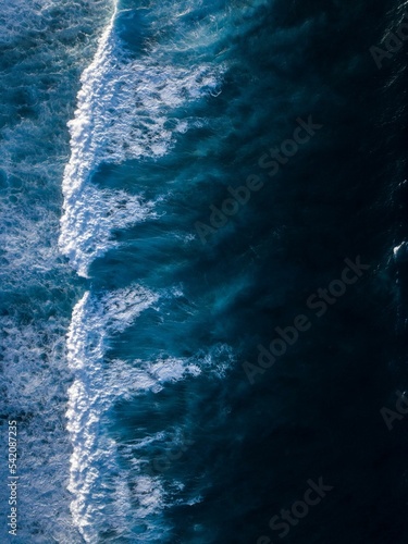 Vertical shot of the waves of blue sea