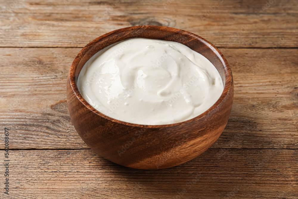 Bowl of tasty yogurt on wooden table Bowl of tasty yogurt on wooden table