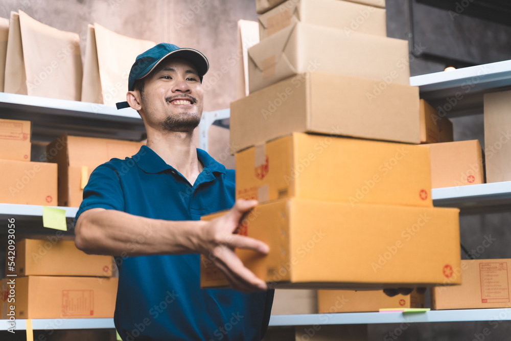 business man in shipping uniform handing customer package prepare for delivery service. man doing work at his small shipping new business and new transportation delivery. business man in shipping uniform handing customer package prepare for delivery service. man doing work at his small shipping new business and new transportation delivery.