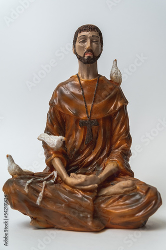 Statuette of Saint Francis of Assisi meditating in the position called lotus or Padmasana. Meditation and religious concept