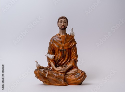 Statuette of Saint Francis of Assisi meditating in the position called lotus or Padmasana. Meditation and religious concept