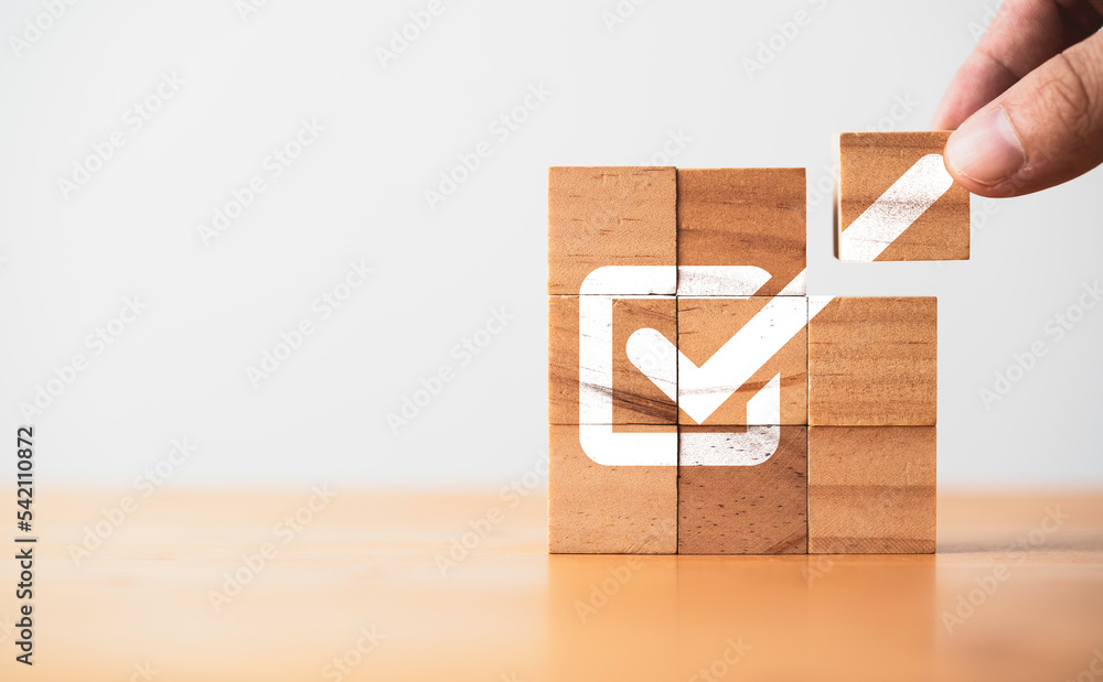 Hand assemble correct tick sign mark on wooden block cube for document approve business project and quality assurance concept. - obrazy, fototapety, plakaty 