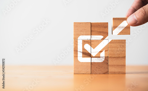 Obraz na płótnie Hand assemble correct tick sign mark on wooden block cube for document approve business project and quality assurance concept
